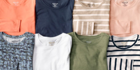 Various colors of women's Perfect Tees laid folded next to each other