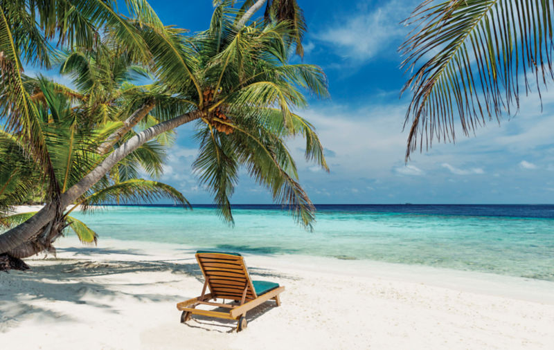 Beach chair in white sand in a tropical location.