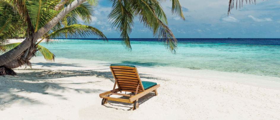 Beach chair in white sand in a tropical location.