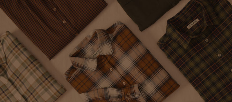 A collection of various plaid patterned shirts laid on a table.