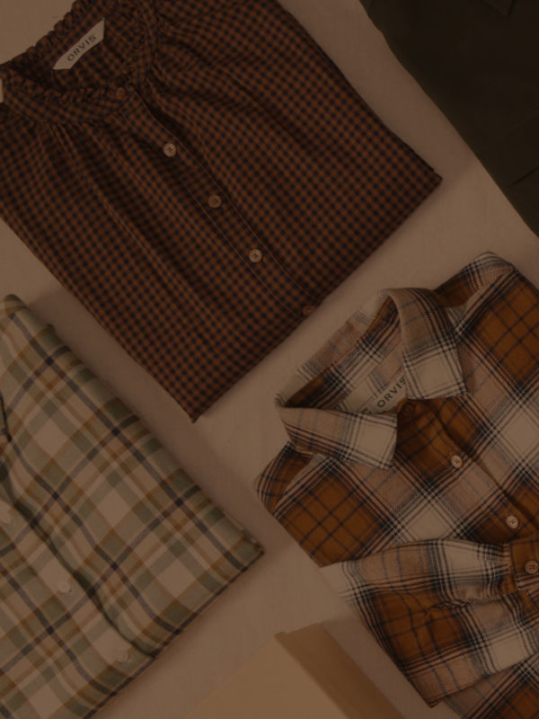 A collection of various plaid patterned shirts laid on a table.