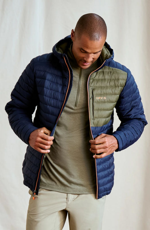 A man wearing a color-blocked navy and olive quilted jacket.