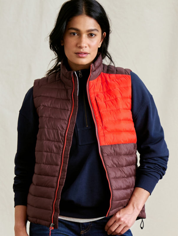 A split image with a scenic forest on the left and a woman wearing a burgundy and red vest over a navy pullover.