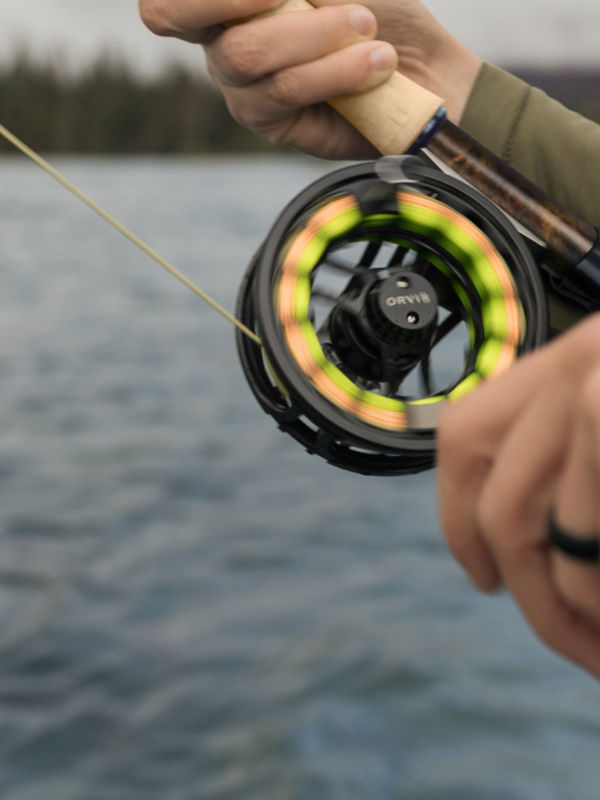 Two hands work a fly rod with the Hydros reel spinning.