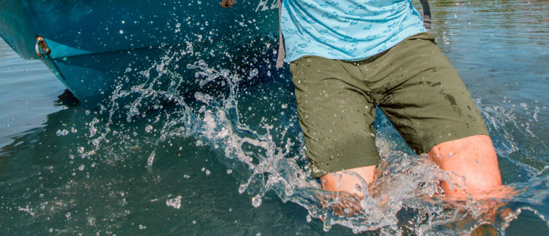 An adventurer hops out of a boat with a splash.
