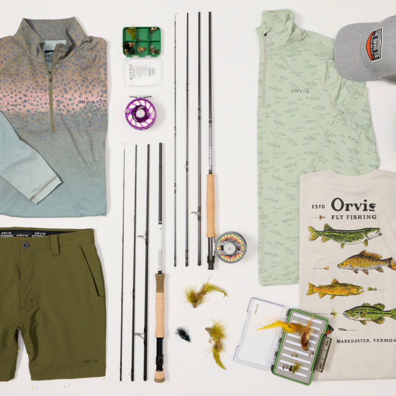 A collection of fishing clothing and equipment laid out on a white background.