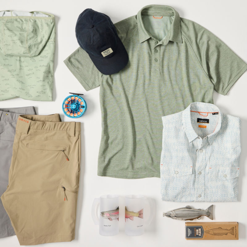 A collection of gifts for men laid out on a white background including clothing, fishing equipment, and beer pints.