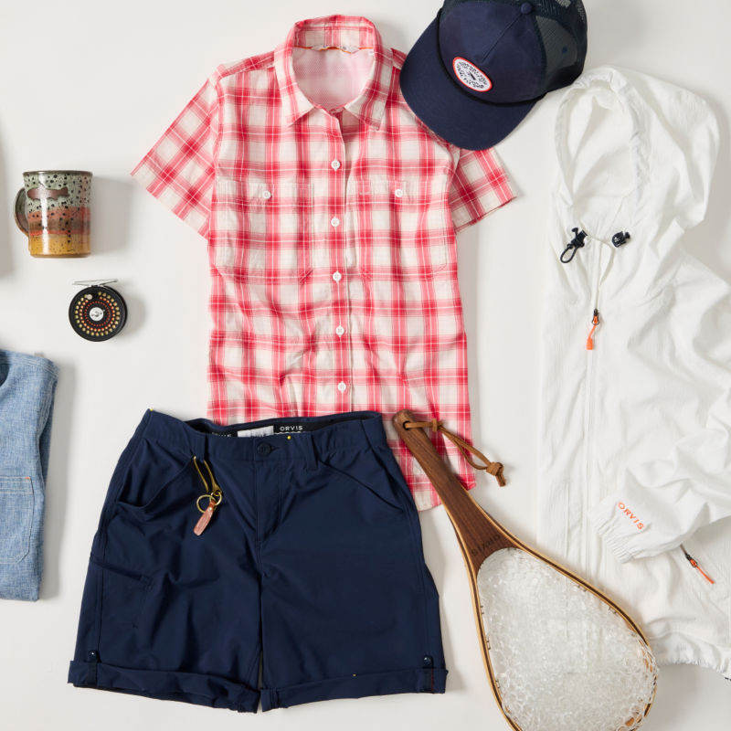 A collection of gifts for women including clothing, fishing equipment, and a mug.