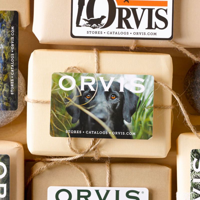 A collection of paper wrapped parcels and gift cards laid on a wooden table.