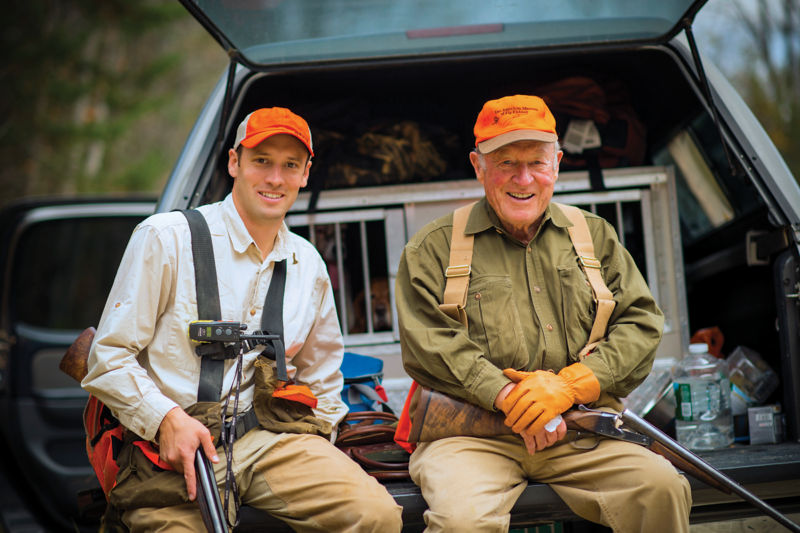 Leigh and his grandson, Simon, sitting on the back of a truck getting ready to hunt.