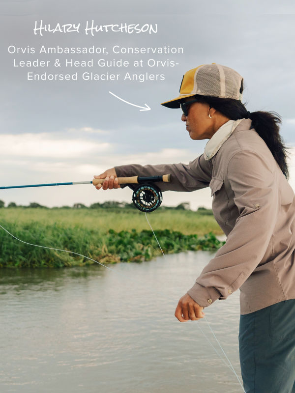 Am angler leans into her cast from the prow of a small boat on a placid river.