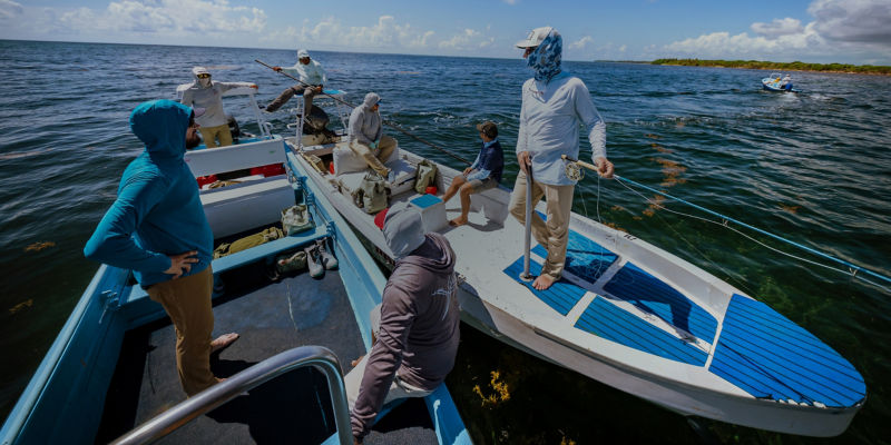 A group of anglers on two boats side by side in the ocean.