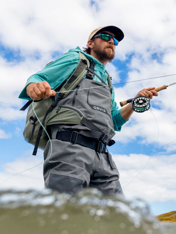An angler wades in knee-deep to find the fish.