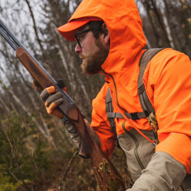 A hunter looks over the shoulder of his hunting jacket decked out in blaze orange.
