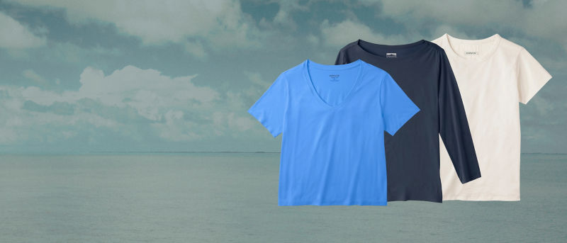 Three women's t shirts superimposed over a background of ocean and sky.