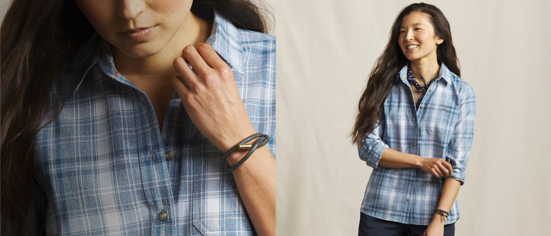 A model wearing a blue plaid button-down shirt over dark blue pants.