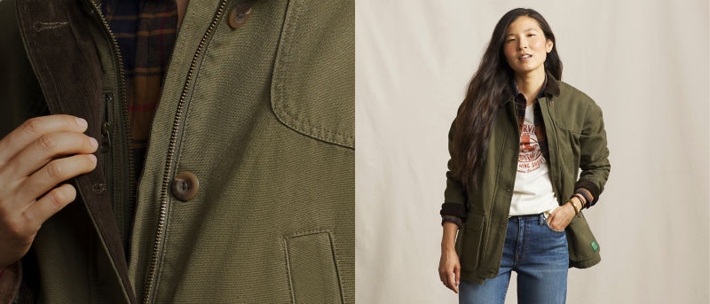 A female model wearing an olive green jacket over a t-shirt and blue jeans.