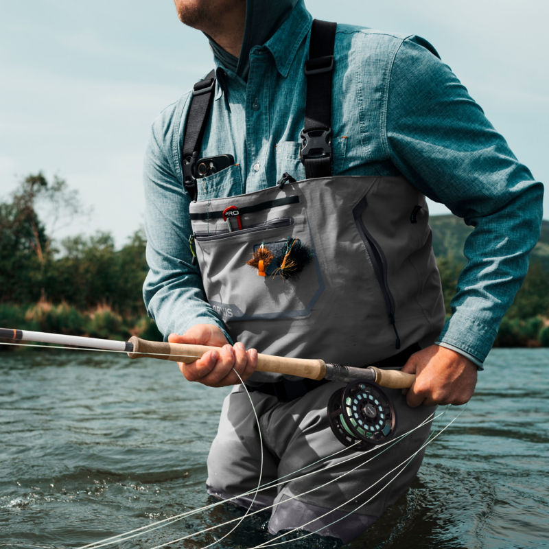 A close-up of an angler holding a two-handed fly rod in a ready position.
