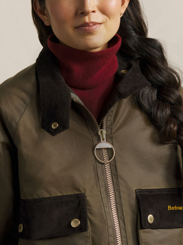 A close-up of a model wearing a Barbour jacket.