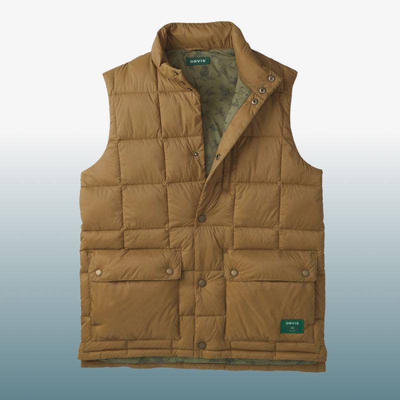 A gold puffy vest laid over a blue gradient background.