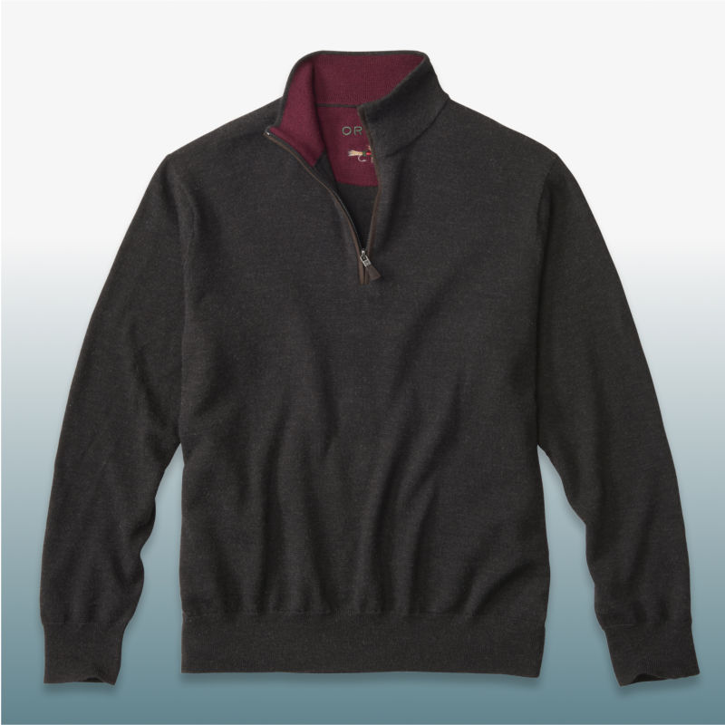 A black merino quarter-zip sweater laid over a blue gradient backgound.