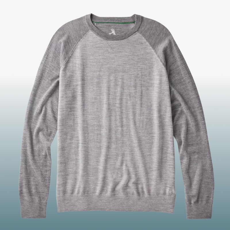 A multi-hues grey sweater laid against a blue gradient background.