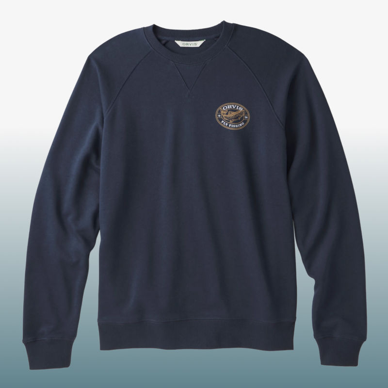 A navy sweatshirt with an Orvis patch on the front laid over a blue gradient background.