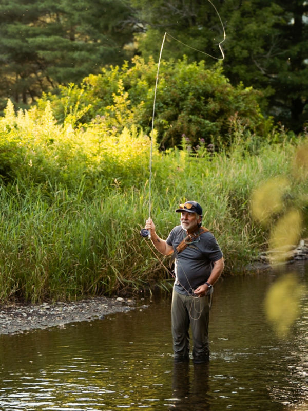 Tom Rosenbauer casting from shin-deep in a quiet river.
