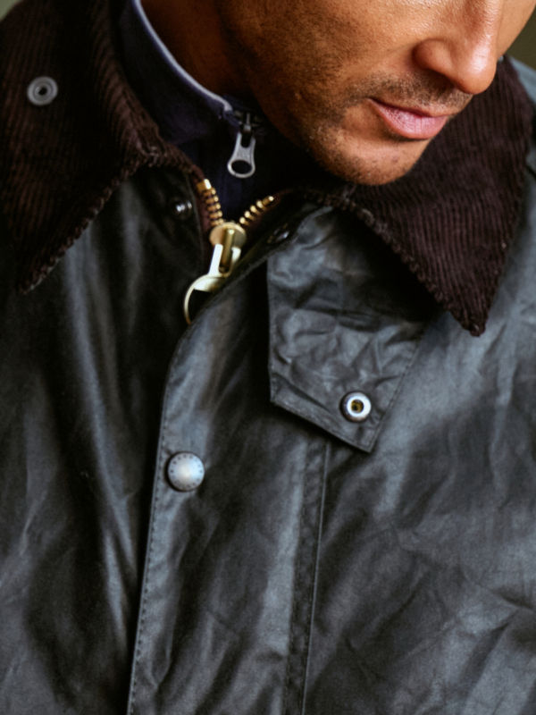 Zoomed in image of a man wearing a black jacket with corduroy collar.