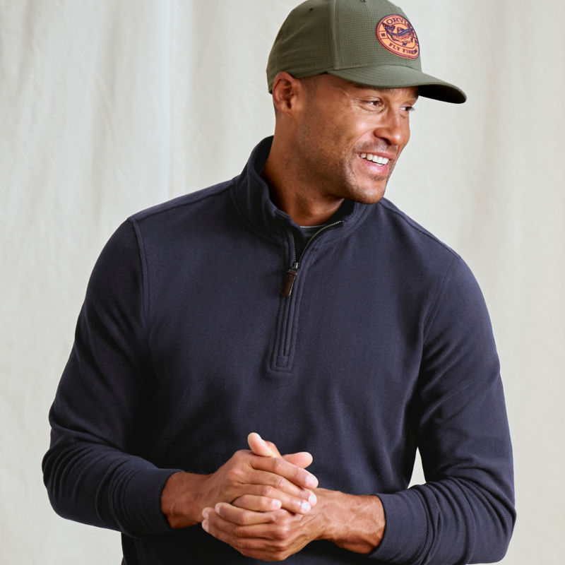 A model wearing a navy quarter-zip sweatshirt.