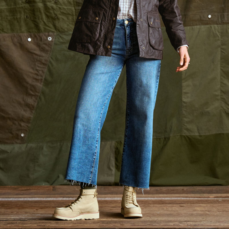 A waist-down view of a model wearing wide-legged jeans.