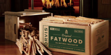 A box full of fatwood fire starter in front of a fire