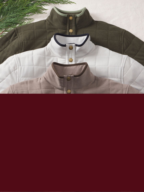 A split image of a burgundy background on the bottom with three carefully laid out quilted sweatshirts on the top.