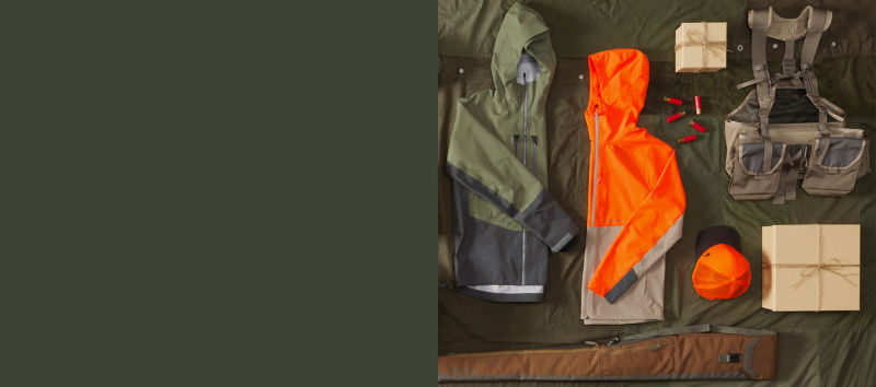 A collection of hunting gear, laid neatly on a green background.