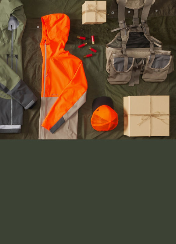 A collection of hunting gear, laid neatly on a green background.