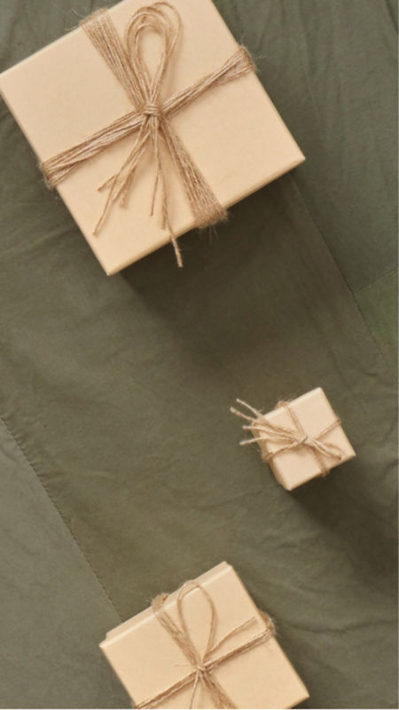 Two brown wrapped gift boxes on an olive cloth background.