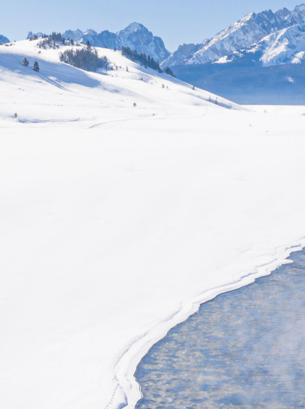 Snowy mountains with river running through it.