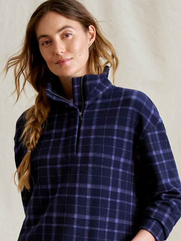 A model wearing a purple-blue plaid patterned quarter-zip fleece.