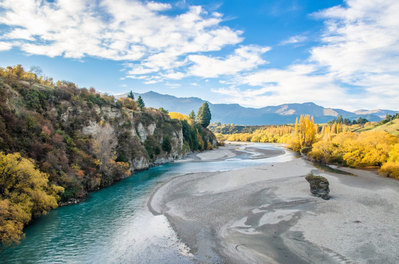 An aerial photo of colorful mountains and a deep turquoise river.