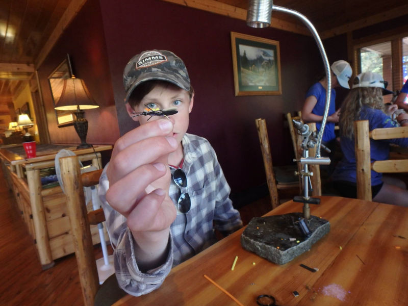 A youth from the PRO Outfitters' Fly Fishing Camp for Kids ties on a fly.