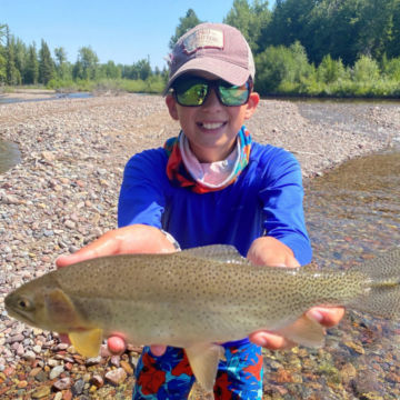 A youth from the PRO Outfitters' Fly Fishing Camp for Kids and his fish.