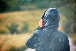 A man wearing a rain jacket in the heavy rain