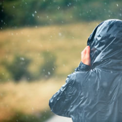 A man wearing a rain jacket in the heavy rain.