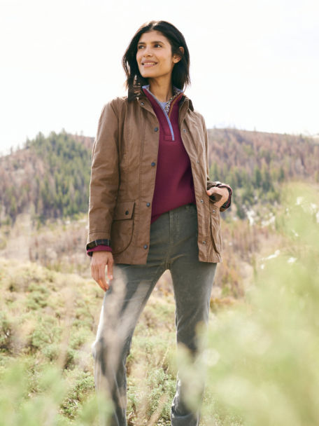 Woman in Barbour® Women's Classic Beadnell Jacket looks out along the countryside as she walks along a trail.