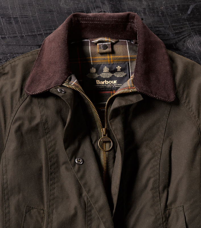 A model wearing a green and yellow color-blocked Barbour jacket.