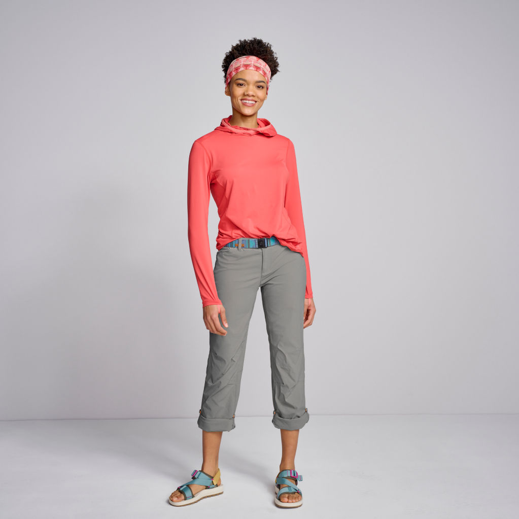 Model wearing Jackson Quick-Dry Natural Fit Straight Leg Pants in gun metal, Women's Sun Defense Hoodie in faded red, Merrell® Alpine Strap Sandals in mineral/olive, and Pistil Edie Headband in hibiscus.