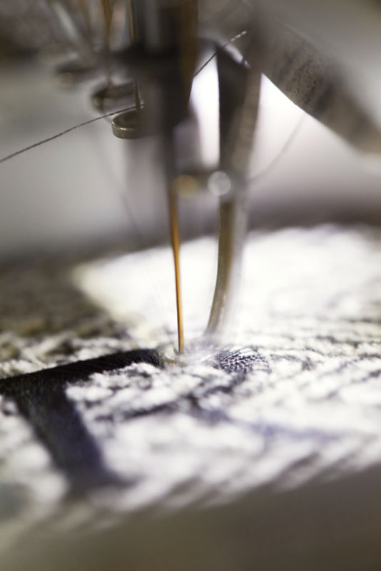 Closeup of personalization needle on sewing machine and fabric.