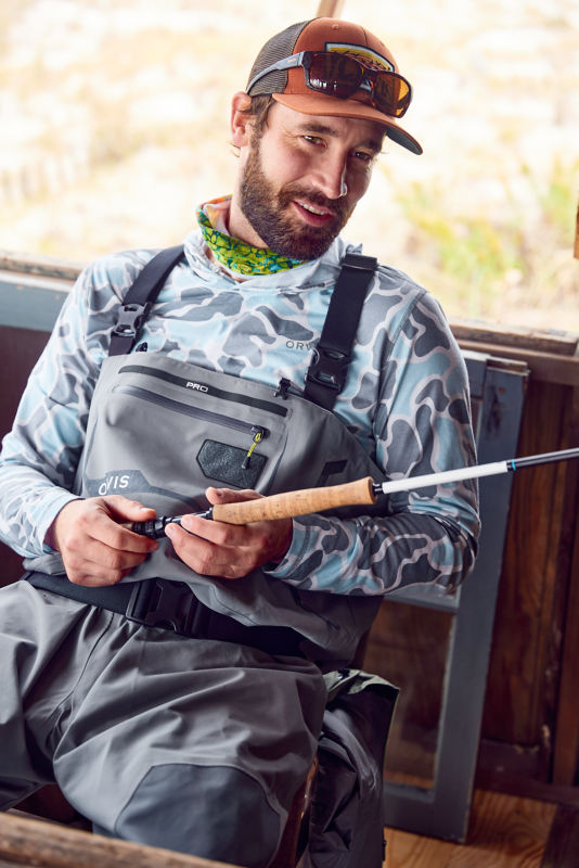 Charley Perkins inspects a fly rod from a bench
