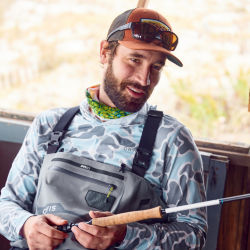 Charley Perkins inspects a fly rod from a bench