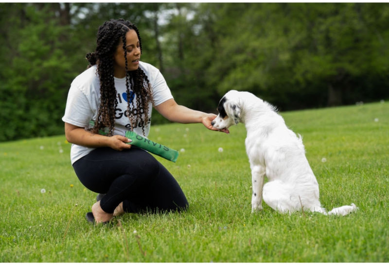 Melinda on the grass giving her dog a treat
